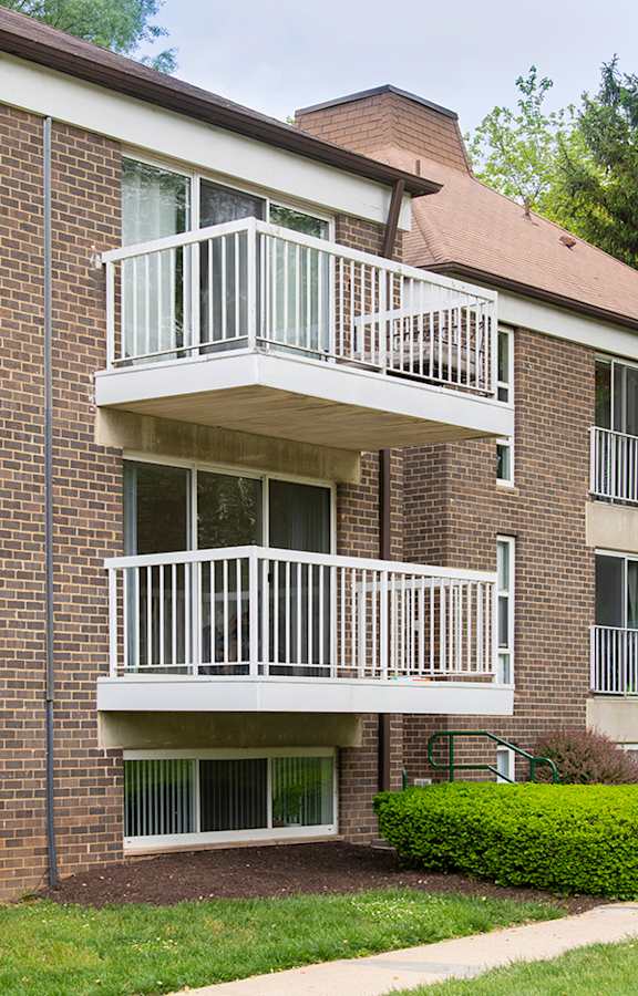 A brick building with a white balcony.