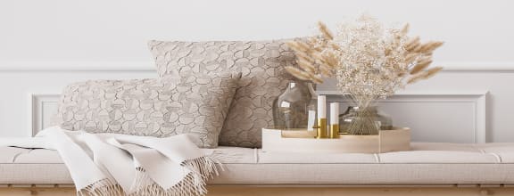 a white bench with a white couch and a vase of flowers at COPPER PLATTE Apartments, GREELEY , CO 80631