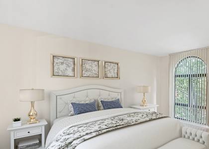 a white bedroom with a bed and a white couch  at The Commons of McLean, Virginia, 22102