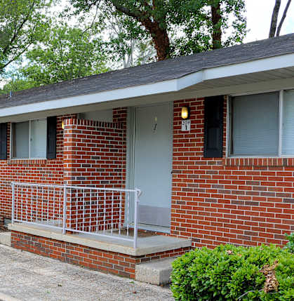 a brick building with a porch and stairs