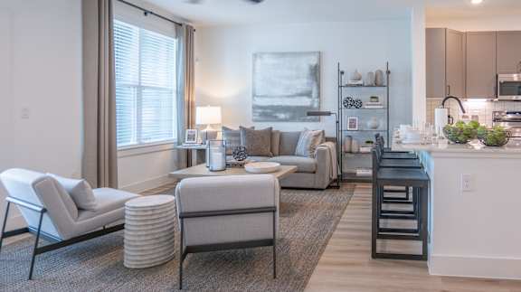 A modern living room with a grey sofa, a white armchair, and a coffee table.