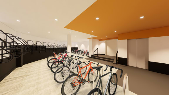 Row of bikes in The Gio Apartments' bike storage room with a staircase and elevator.