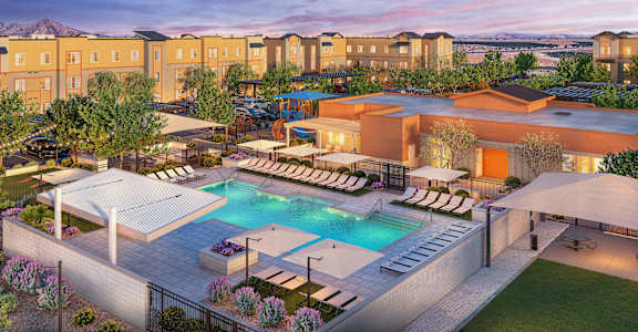 A large outdoor swimming pool surrounded by lounge chairs and umbrellas.