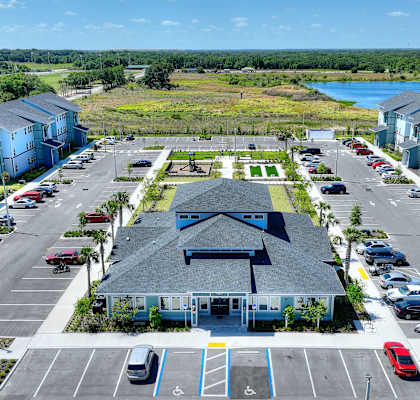 an aerial view of a parking lot with houses and a lake