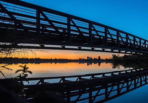 a bridge over a body of water at sunset