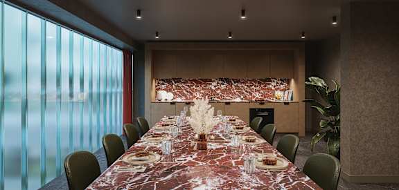 a long dining table in a room with large windows and a wall of glass