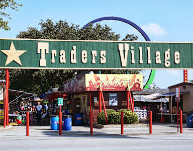 A sign that says Traders Village in front of a building.