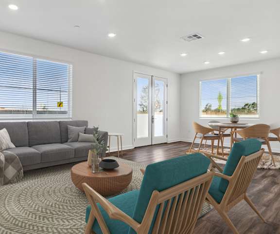 A living room with a grey couch, a wooden coffee table, and a rug.