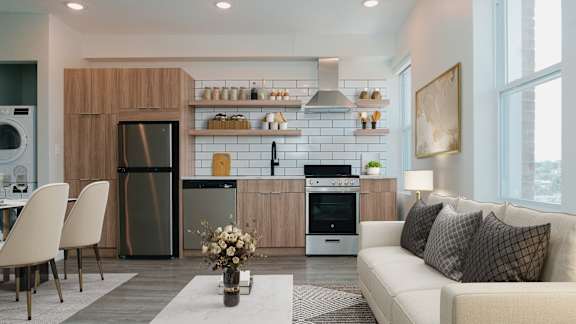 A modern kitchen with a refrigerator, oven, and a dining table with chairs.