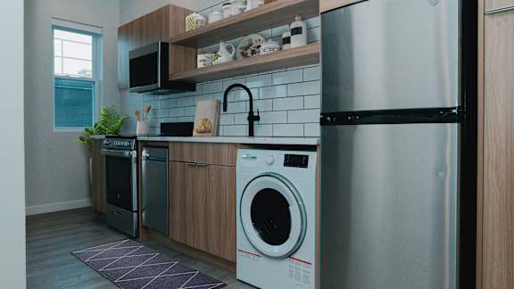 A modern kitchen with a washing machine and a refrigerator.