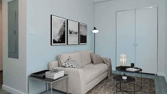 A living room with a couch, a table, and a lamp.