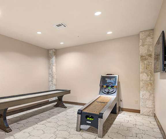 a game room with a shuffleboard table and a bench at Lakeline East Apartments, Cedar Park, TX