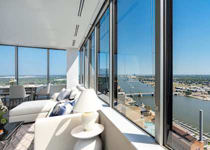 a room with a view of a river and a city from a skyscraper