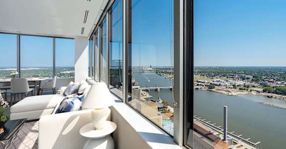 a room with a view of a river and a city from a skyscraper
