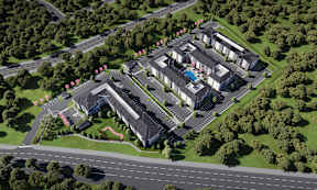 An aerial view of a residential complex with multiple buildings and a road running through it.