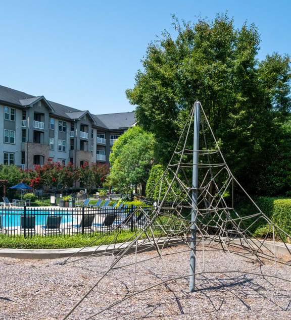 a playground with a christmas tree in front of an apartment building