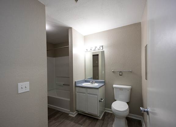 a bathroom with a toilet and a sink and a shower at Magnolia Pointe Apartments in Duluth, GA
