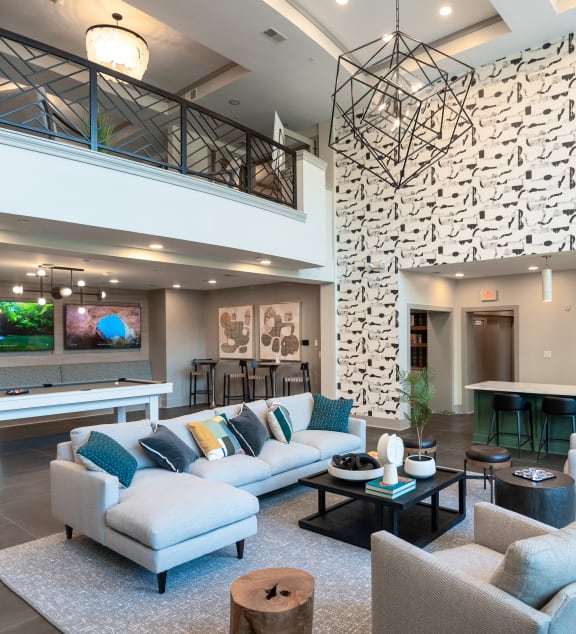a living room with couches and chairs and a pool table