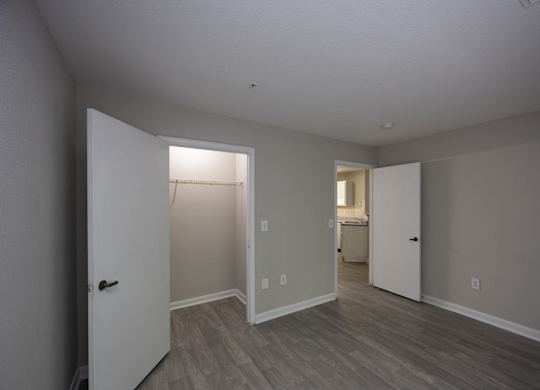 an empty living room with a door to a closet and a bathroom at Magnolia Pointe Apartments in Duluth, GA