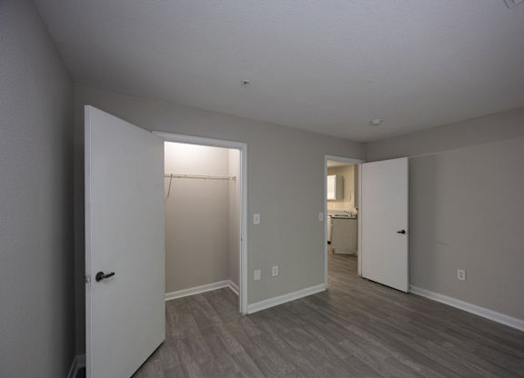 an empty living room with a door to a closet and a bathroom at Magnolia Pointe Apartments in Duluth, GA