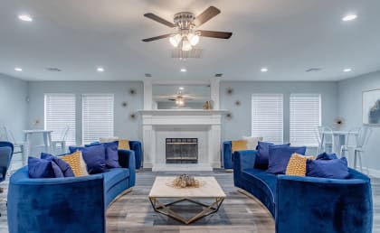 a living room with blue couches and a fireplace