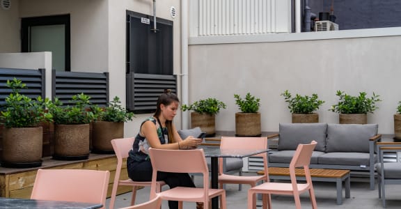 a woman sitting at a table with her cell phone