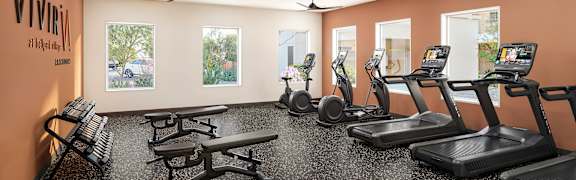 Fitness center with treadmills and weight benches at Vivir at Ballpark Village Apartments, Goodyear, AZ 85338