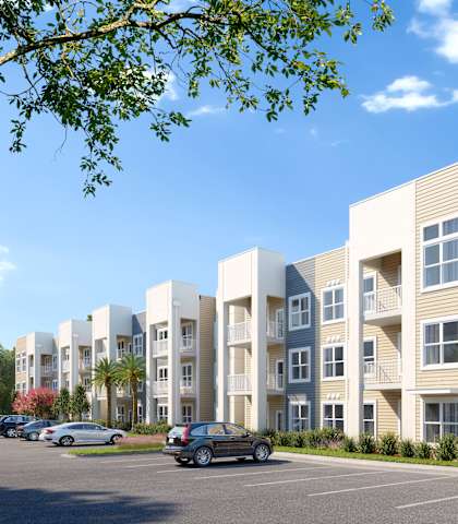 A row of modern apartment buildings with cars parked in front. at The Mira Apartments, Florida
