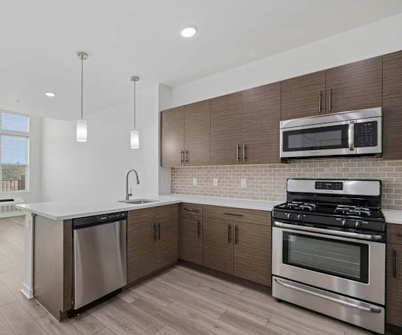 A modern kitchen with stainless steel appliances and wooden cabinets.