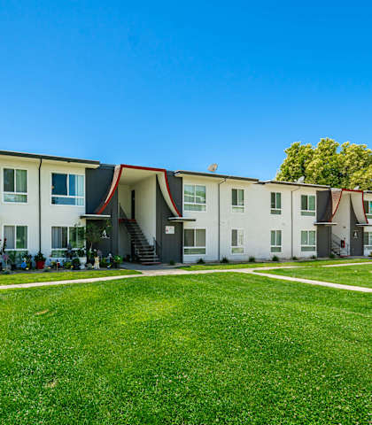 a row of houses with a green lawn in front of them