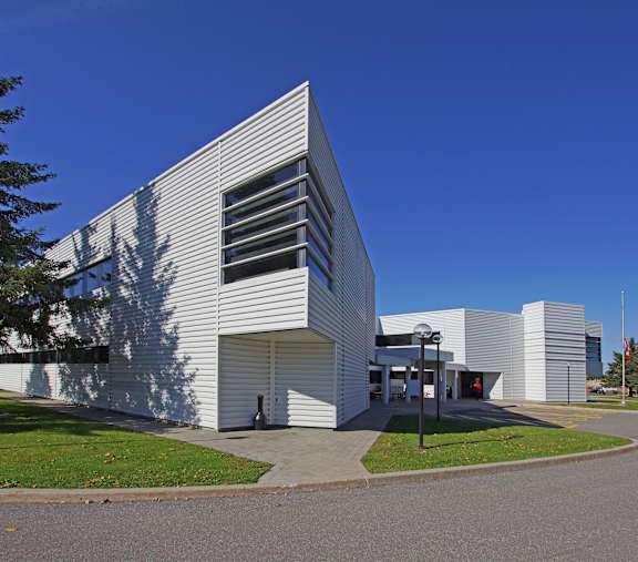 A modern building with a white exterior and a triangular facade.