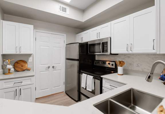 a kitchen with stainless steel appliances and white cabinets