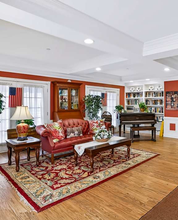 A living room with a red couch and a rug.