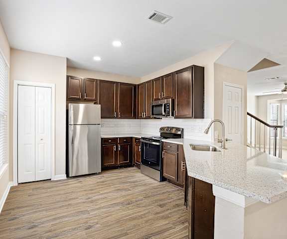 a kitchen with dark wood cabinets and white countertops at Las Brisas Apartment Homes, Round Rock, 78665