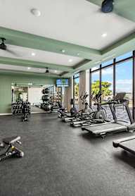 A gym with treadmills, weights, and exercise equipment.