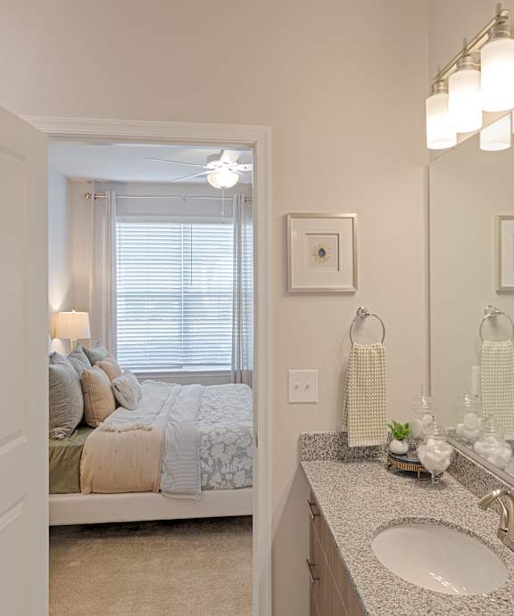 A bathroom with a toilet, a sink, a towel rack, a shelf, and a picture.