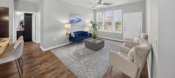 A living room with a blue sofa and a grey rug.