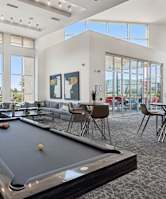 A pool table in a room with a large window and a view of the outside.