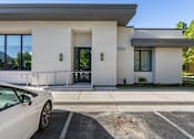 Thumbnail 21 of 28 - A white car is parked in front of a modern building. at Siena Villas Apartments, Utah, 84097