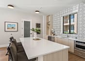 Thumbnail 4 of 28 - A modern kitchen with a white countertop and dark chairs. at Siena Villas Apartments, Orem, 84097