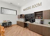 Thumbnail 32 of 52 - A Makers Room with a desk, chairs, and a cabinet with tools and electronics at Solhavn Apartments, American Fork, 84003