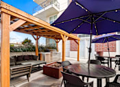 Thumbnail 38 of 49 - Patio with a wooden pergola and tables with umbrellas at 200 City View, Provo, UT
