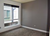Thumbnail 4 of 5 - A room with a large window and a view of a building outside.
