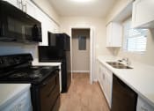 Thumbnail 4 of 11 - a kitchen with white cabinets and black appliances and a black refrigerator