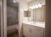 Thumbnail 6 of 11 - a bathroom with a sink and a shower and a mirror