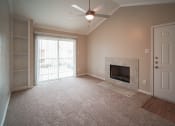 Thumbnail 9 of 11 - an empty living room with a fireplace and a ceiling fan