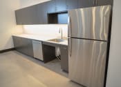 Thumbnail 6 of 23 - an empty kitchen with a refrigerator and a sink