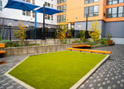 Thumbnail 16 of 23 - a courtyard with benches and grass in front of a building
