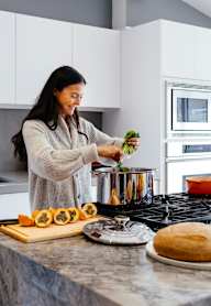 A woman is preparing food on a kitchen counter.