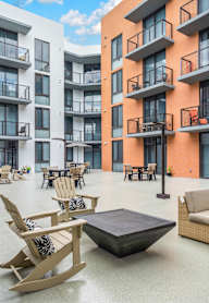 A patio area with furniture and a building in the background.